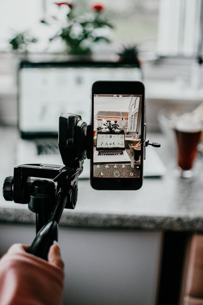 Najim Accesorios Móvil. Creative setup using mobile phone for capturing a workspace scene, emphasizing smartphone photography.
